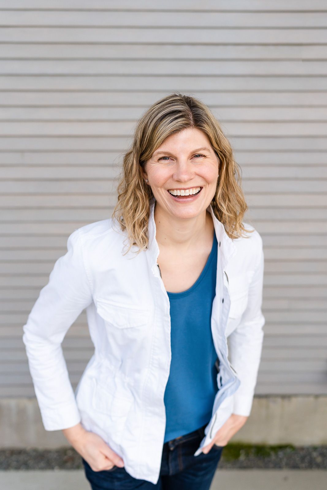 Woman smiling for a photo in front of a wood panel backdrop.