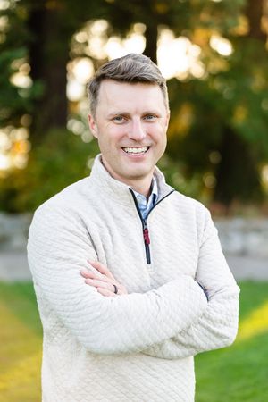 Man crossing his arms and smiling for a photo.