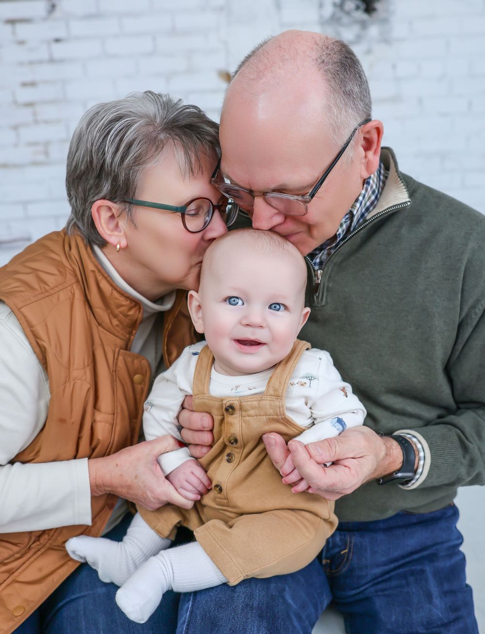 Grandparents sharing tender moments with baby in casual portrait series.