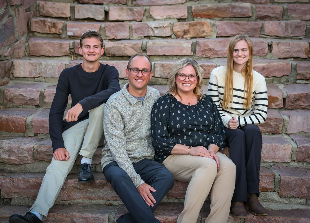 Family members sitting on rustic stone steps during a casual photo session.