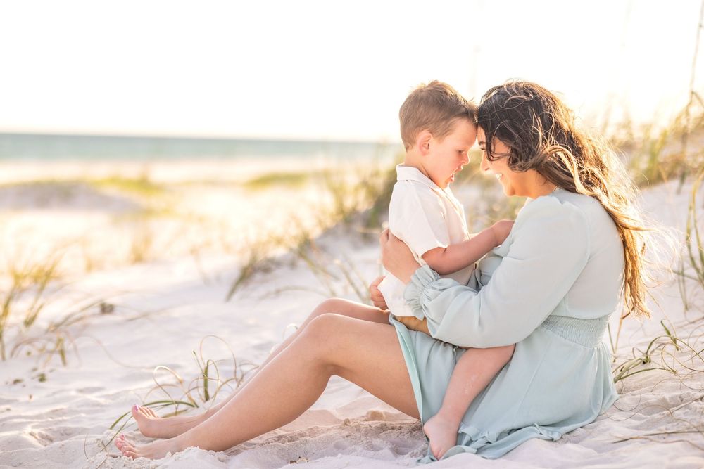 A romantic couple embraces on a sandy beach during sunset creating a dreamy coastal scene.