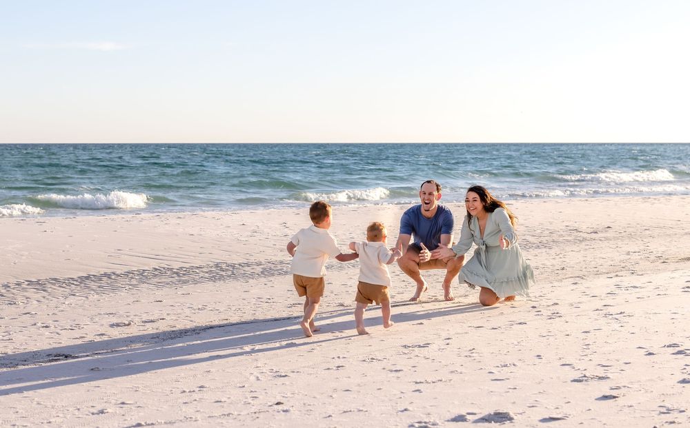 Family enjoying a playful moment together on a pristine beach with gentle waves rolling in.