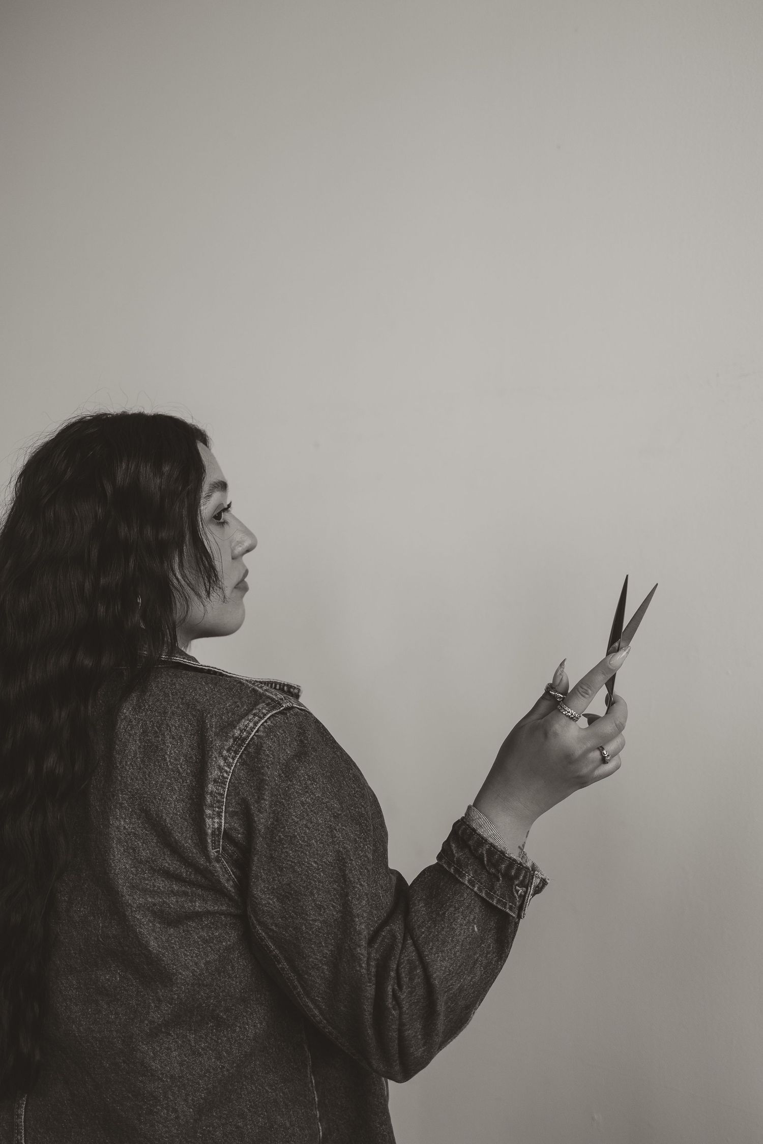 A series of black and white photos showing a person in profile view holding scissors in different dramatic poses.
