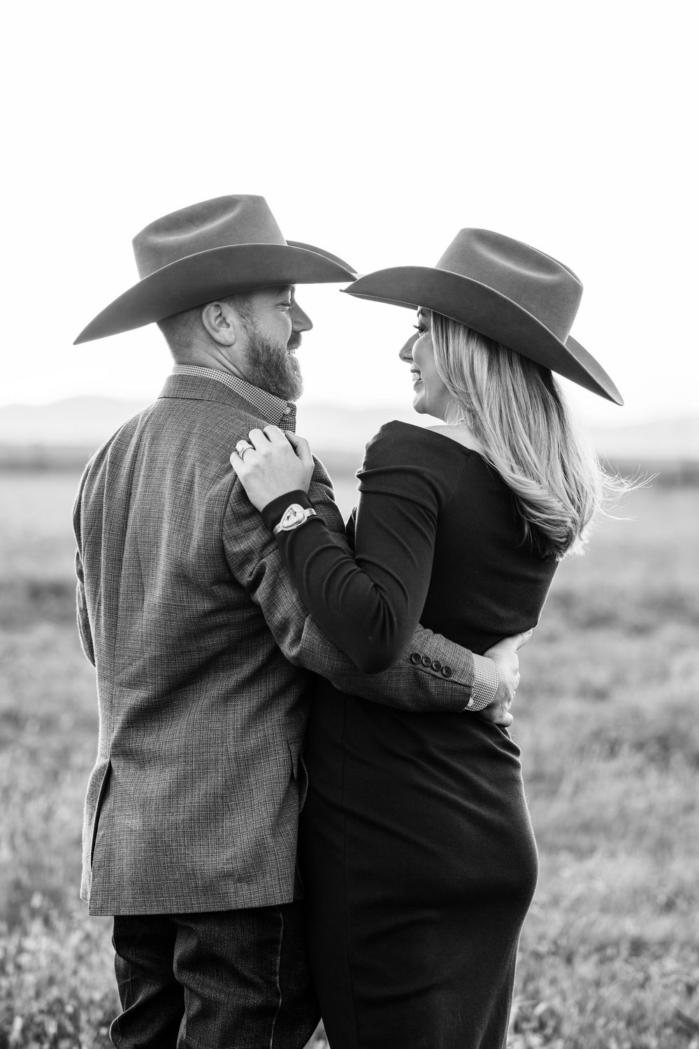 A black and white series of three photos showing a couple in cowboy hats embracing in a rustic outdoor setting.
