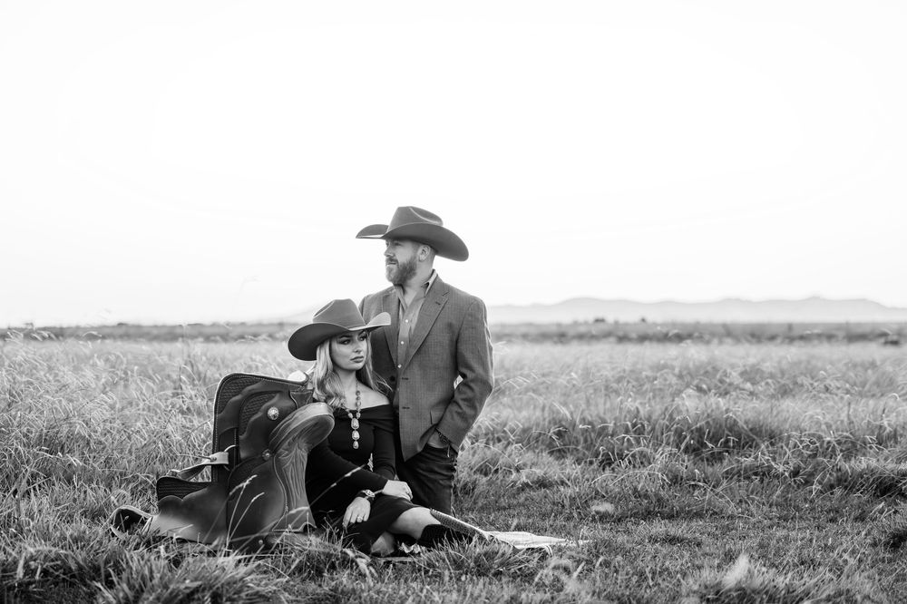 A vintage black and white photograph shows people resting and lounging in a grassy field on a summer day.