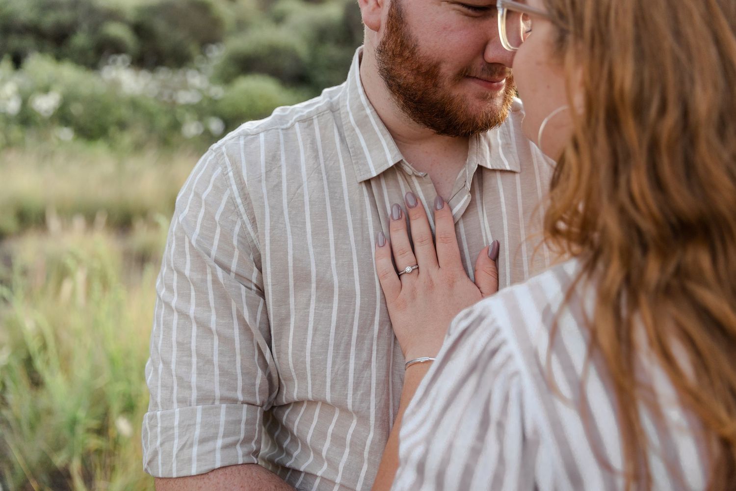 Engaged couple at Bombo Headlands with cliffs and ocean at sunset