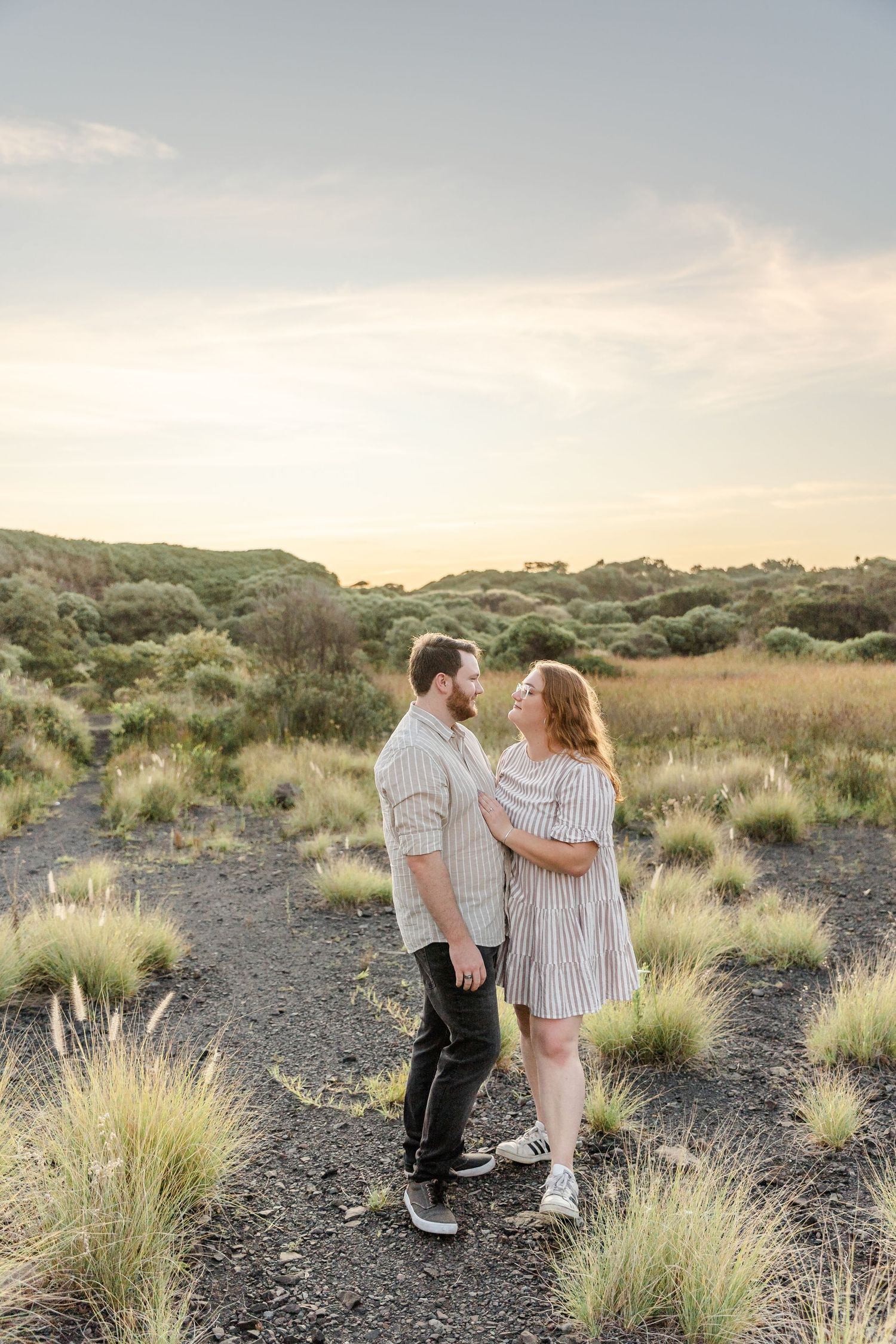 Engaged couple at Bombo Headlands with cliffs and ocean at sunset