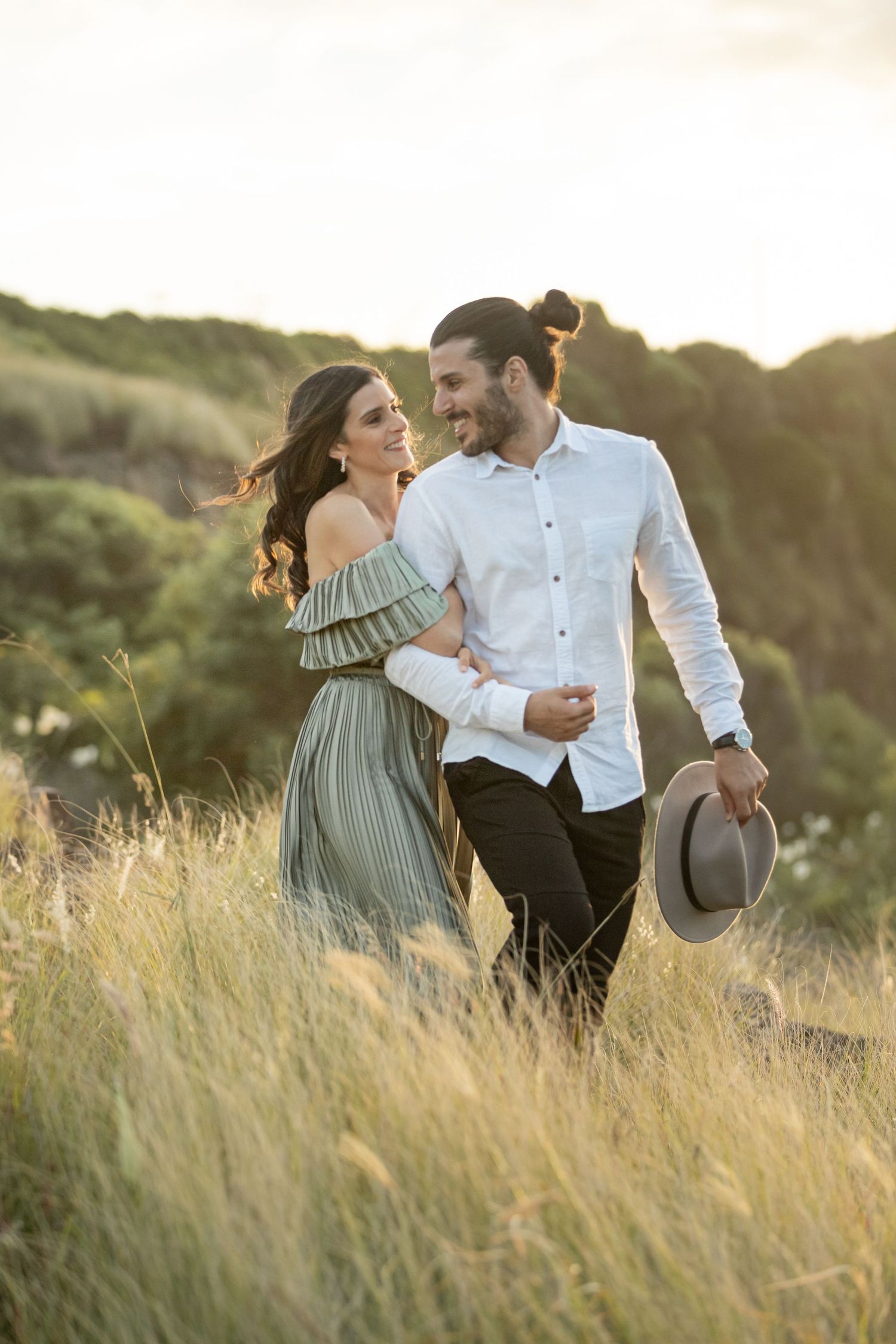 Engaged couple at Bombo Headlands with cliffs and ocean at sunset