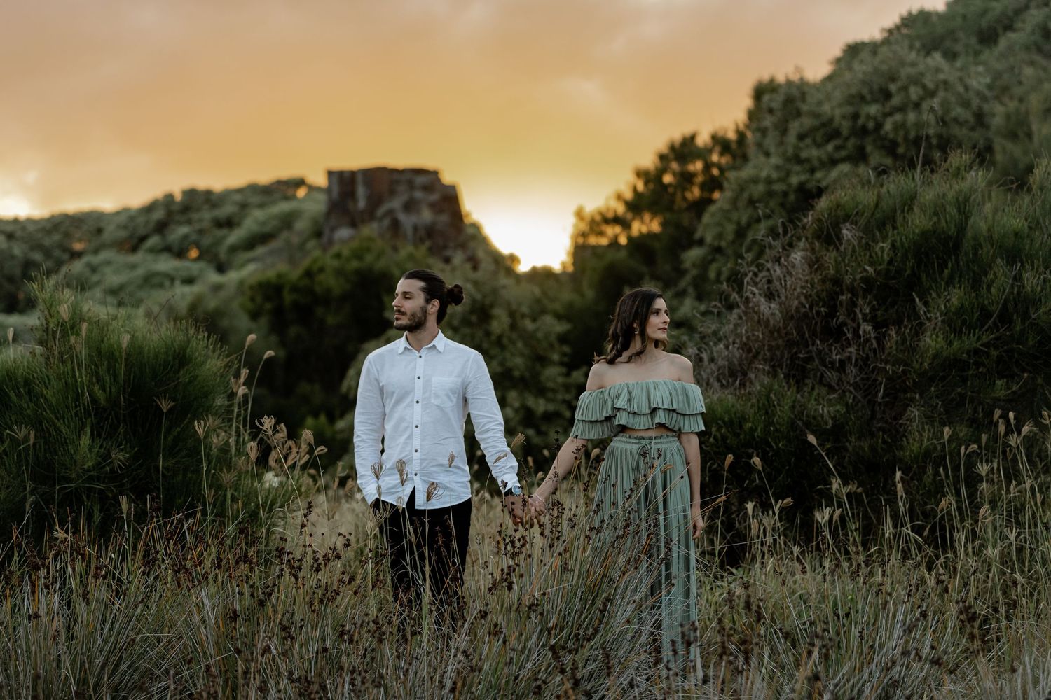 Engaged couple at Bombo Headlands with cliffs and ocean at sunset