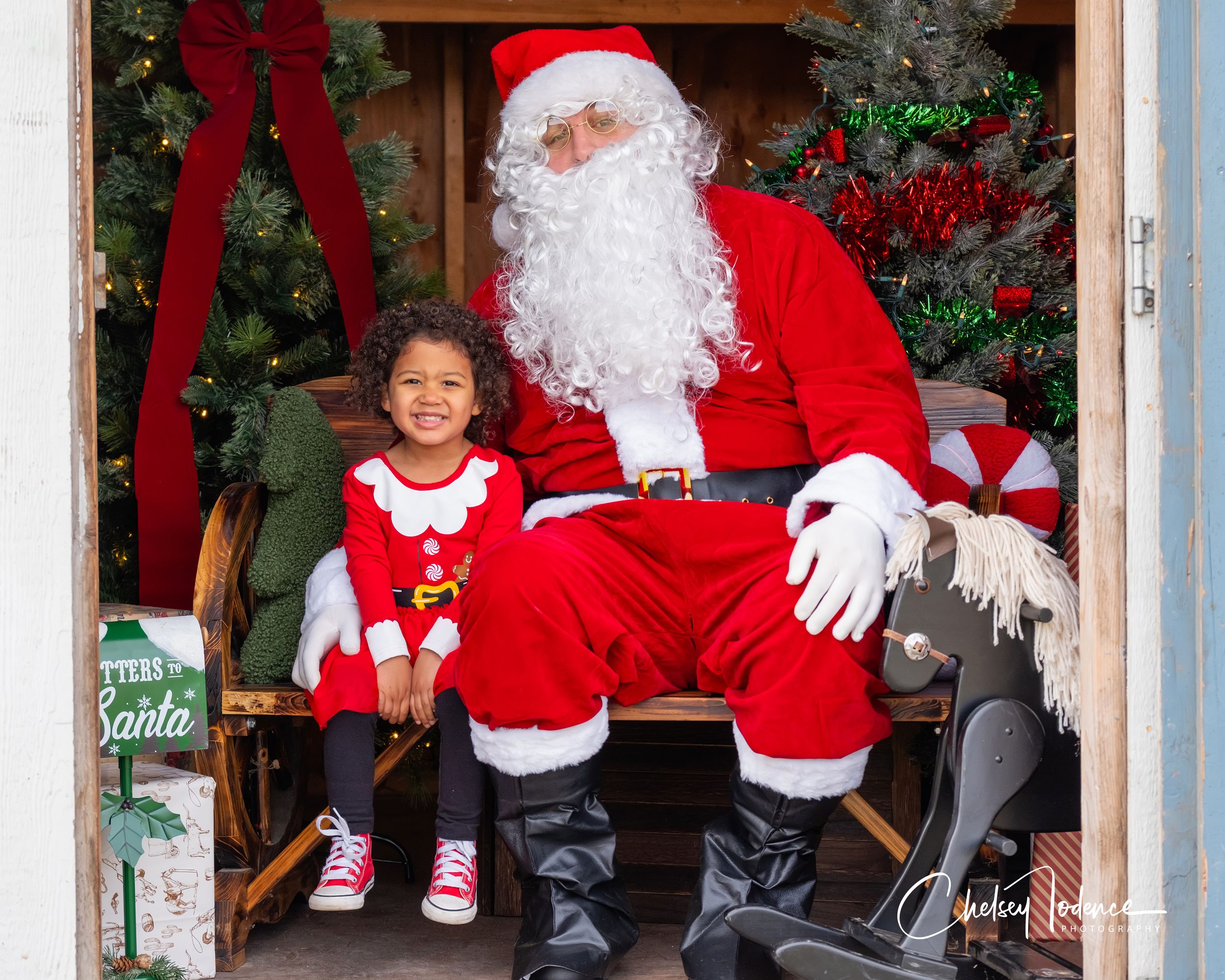 Happy toddler sitting with Santa during a Christmas mini session in Petaluma, Sonoma County Santa