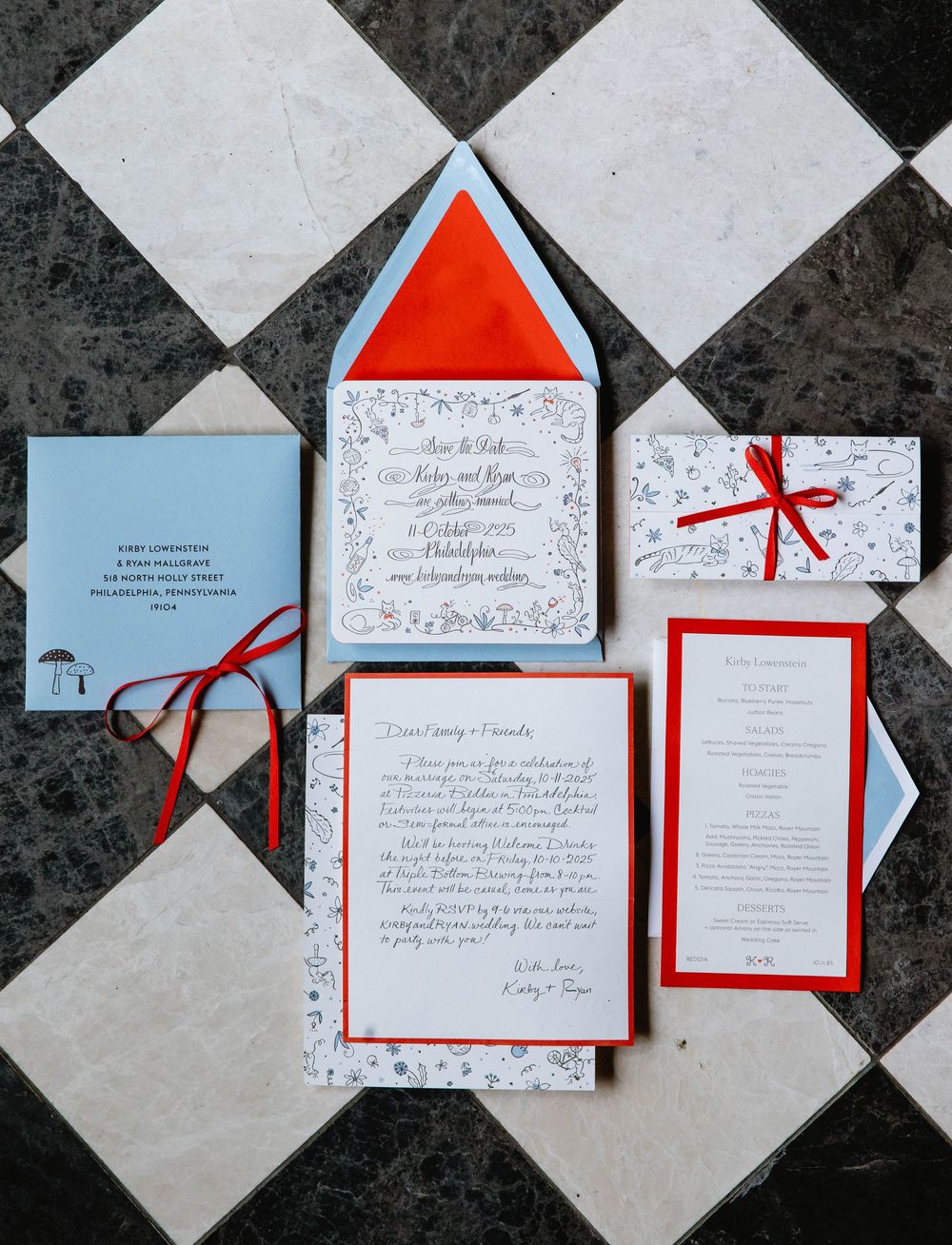 Wedding invitation suite with red and blue accents displayed on checkered tile floor. Pizzeria Beddia Wedding. Fishtown Philadelphia, PA.