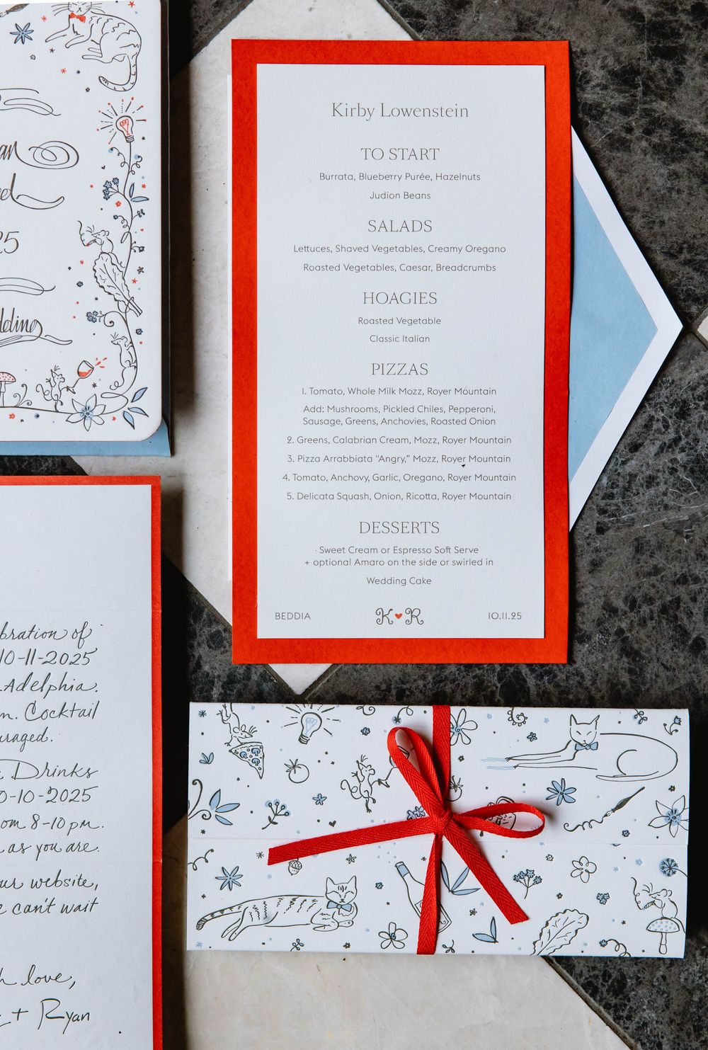 Wedding menu card with red border and elegant typography displayed on marble surface. Pizzeria Beddia Wedding. Fishtown Philadelphia, PA.