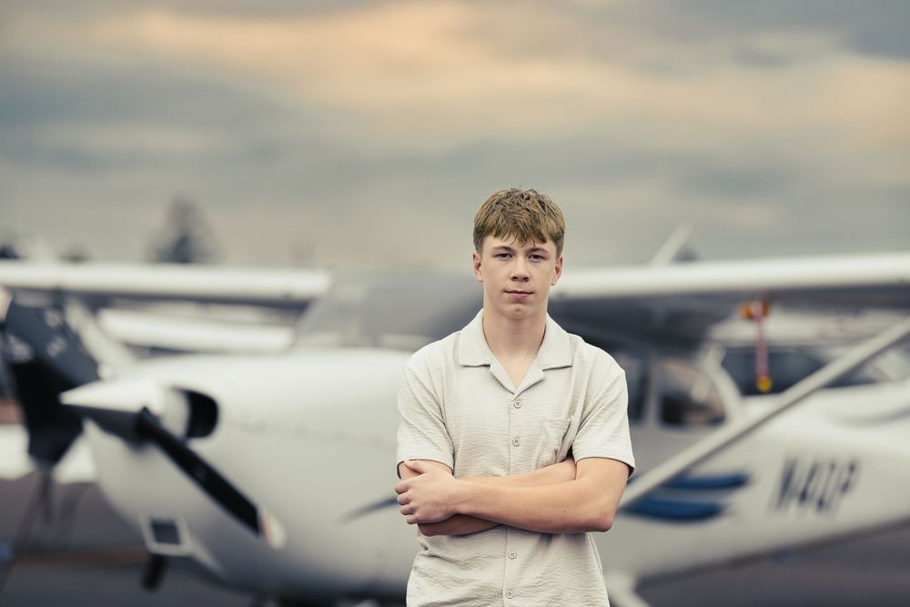 Row of small private planes lined up at an airfield during golden hour.