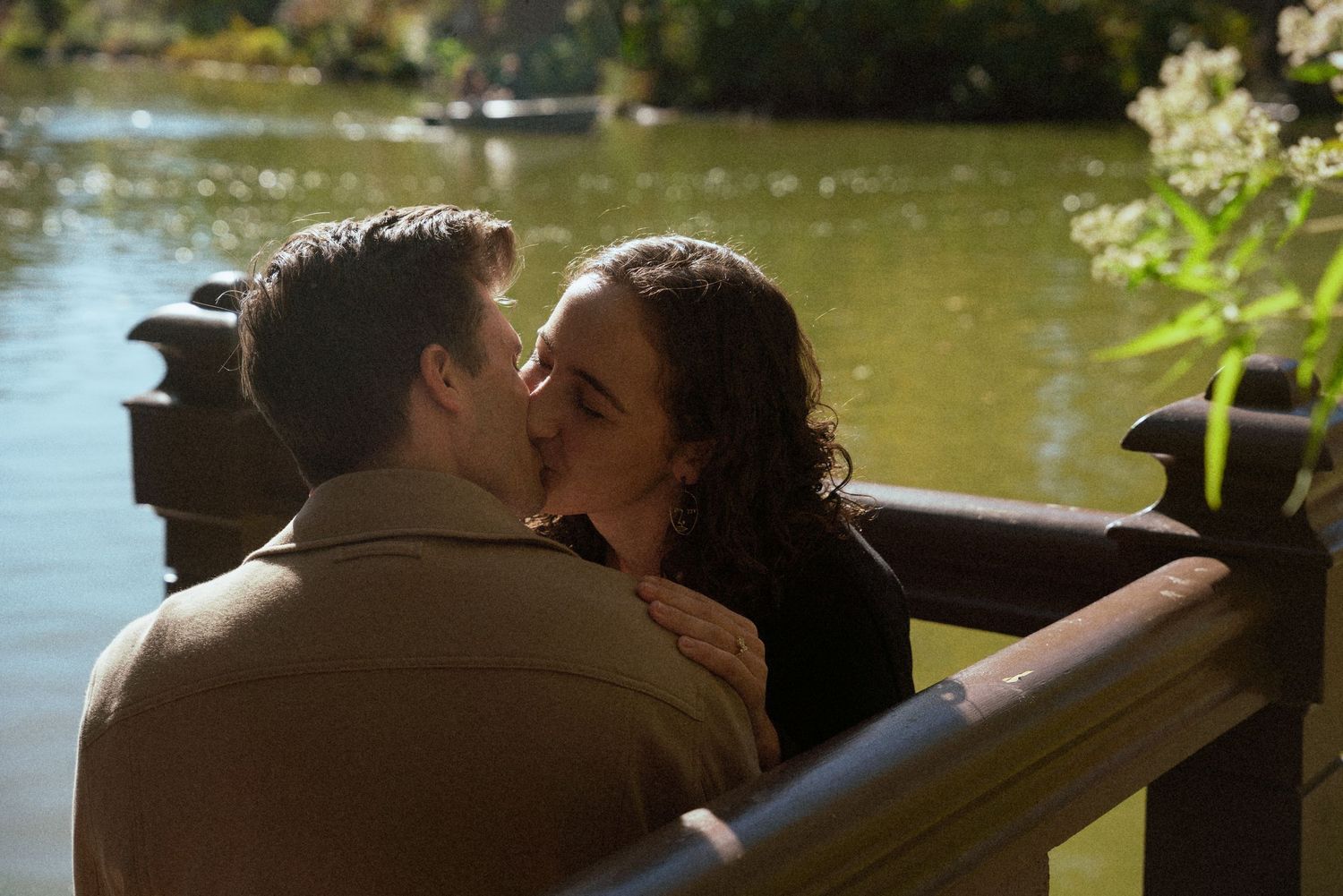 A romantic sunset moment by a lake with golden light filtering through trees.