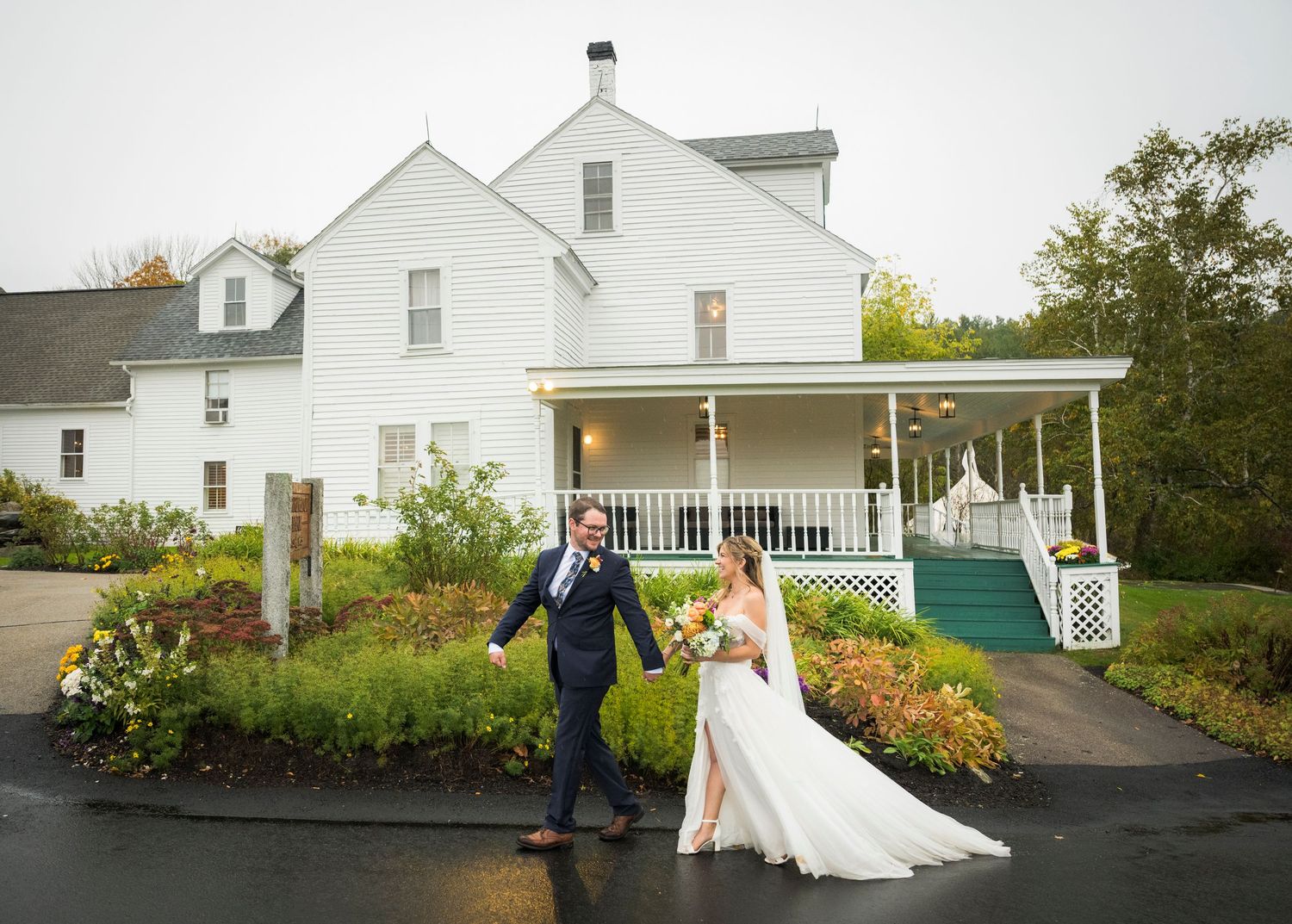 A series of five wedding photographs showing a couple in formal attire walking and posing outside a white house with gardens.