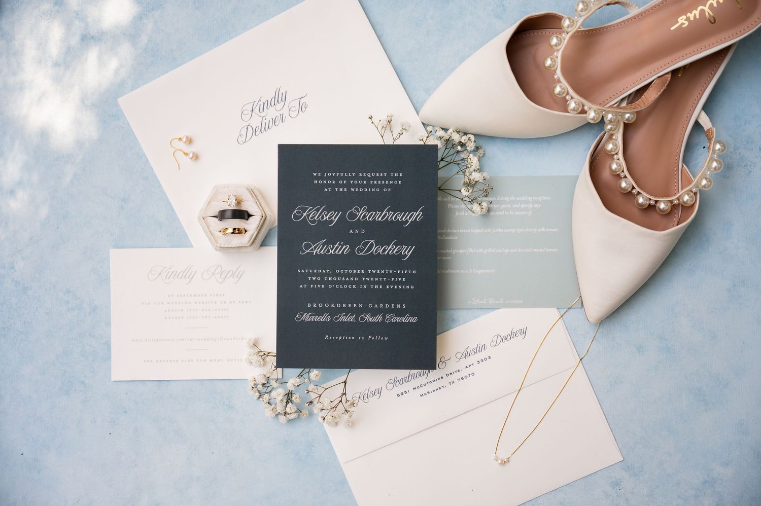 Wedding stationery and invitations arranged on a light blue background.