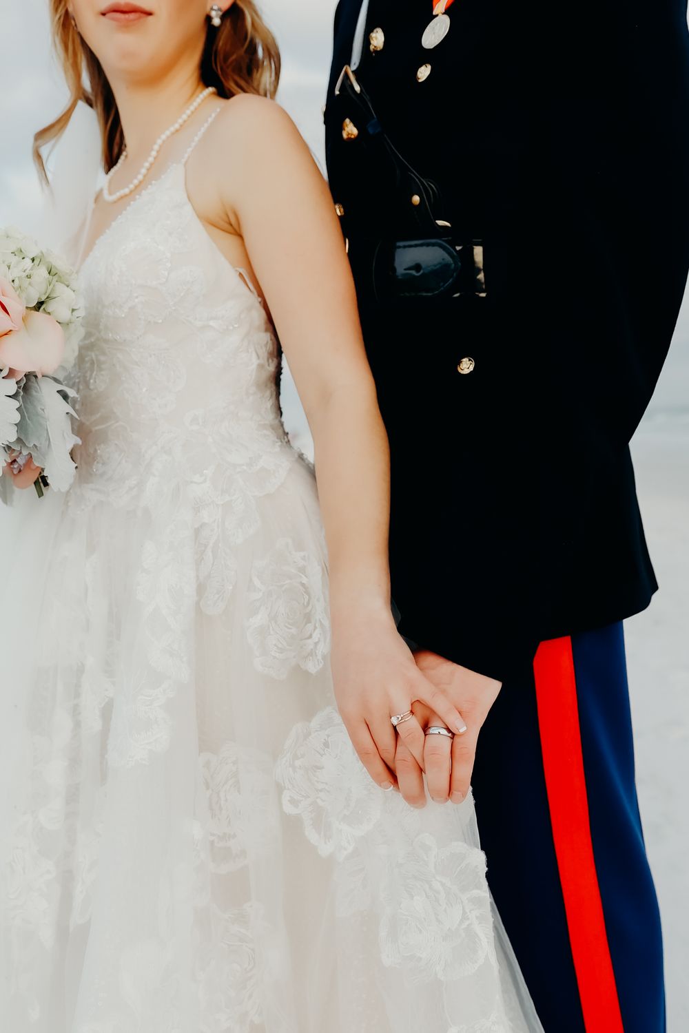 Close-up of bride and groom in military dress uniform embracing.