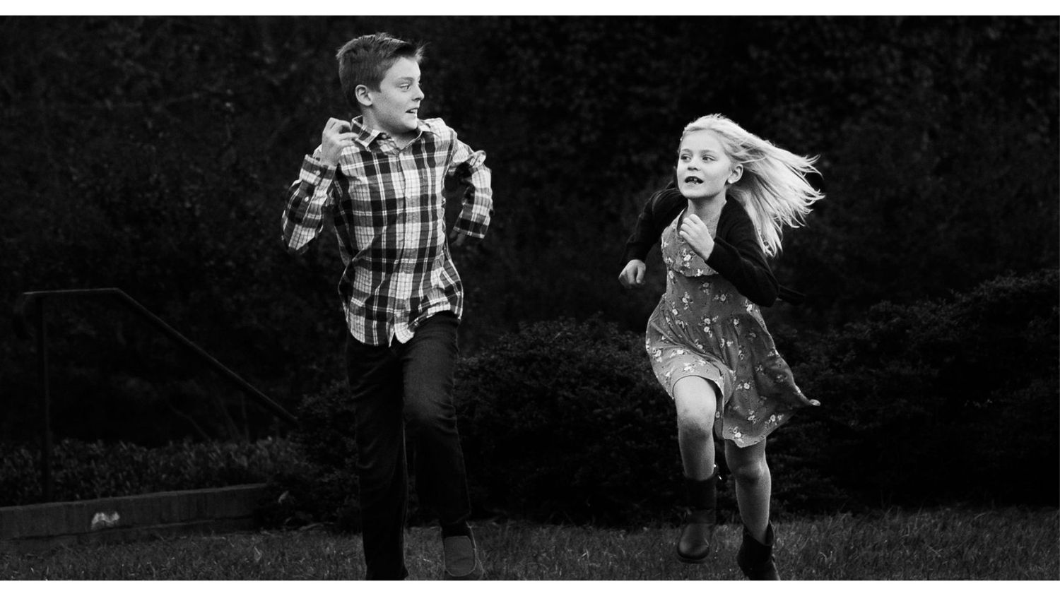 A black and white photograph of people dancing and celebrating at an outdoor event.