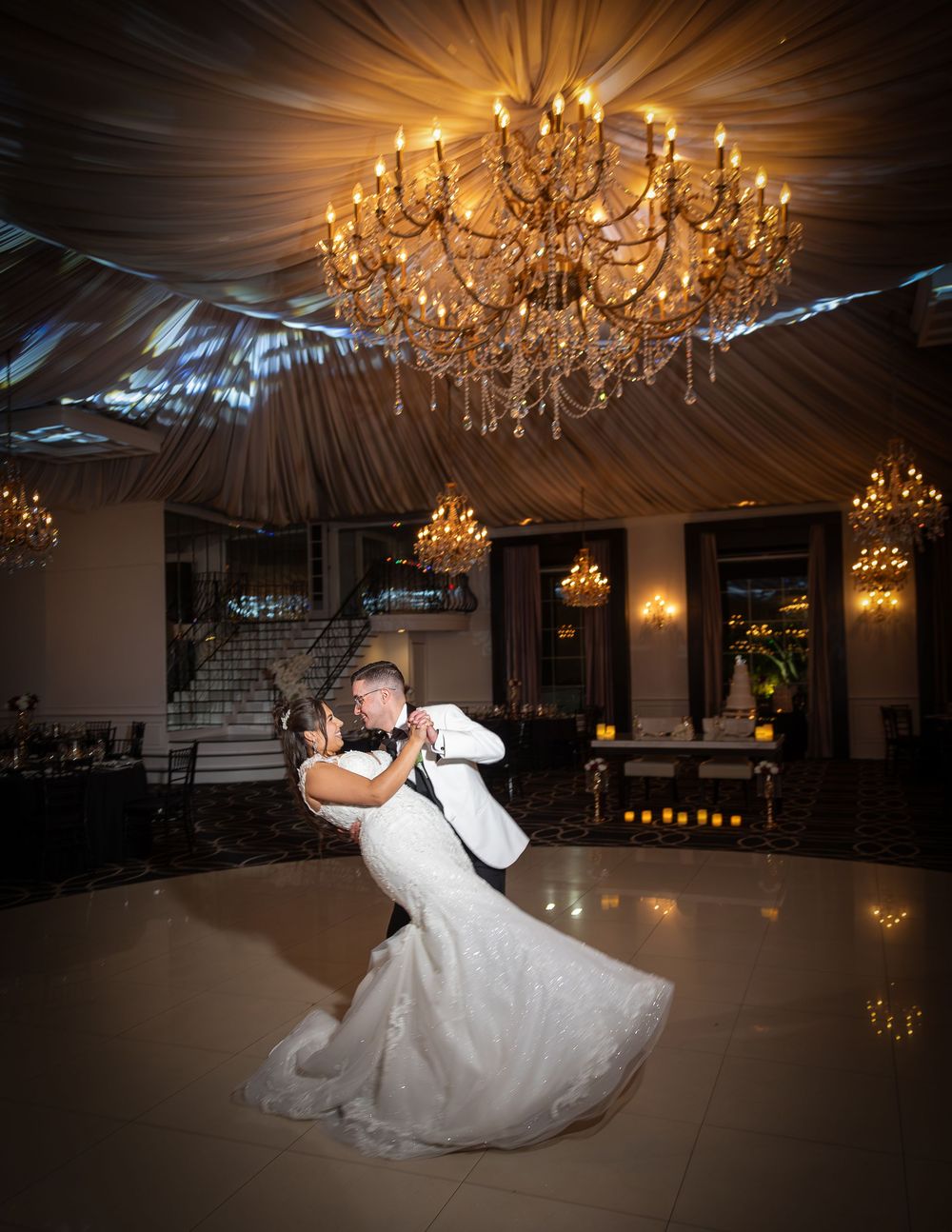 A romantic wedding dance sequence under elegant crystal chandeliers in a grand ballroom.