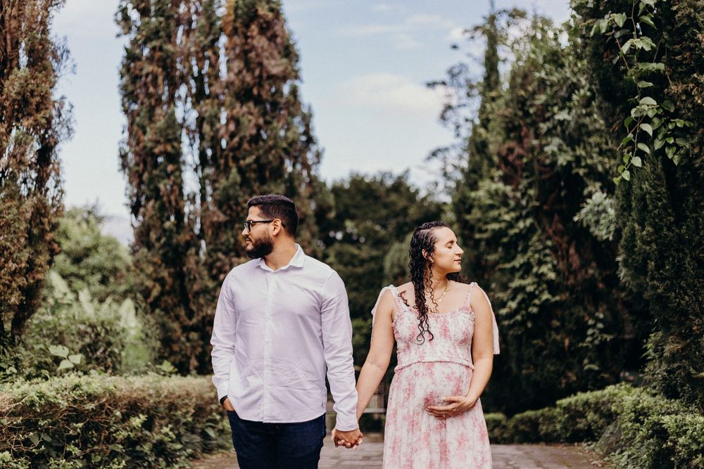 A romantic outdoor photo series showing a couple walking and embracing among tall trees on a sunny day.