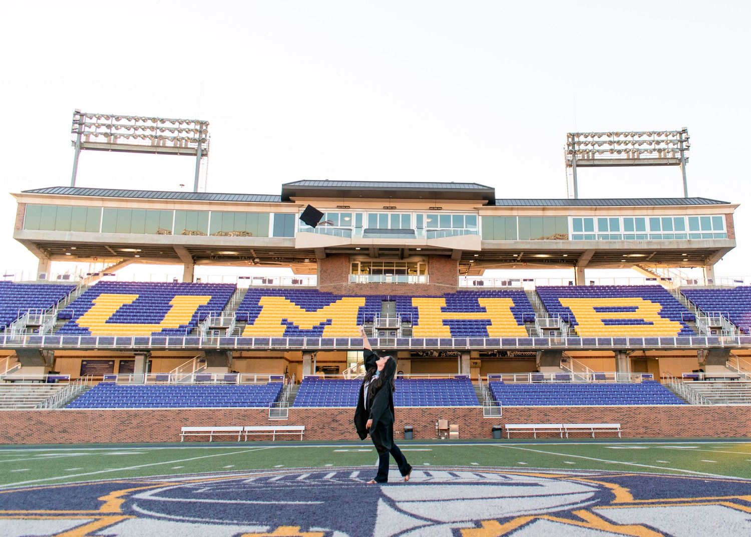 Graduate posing at UMHB sign in Belton Texas during senior session