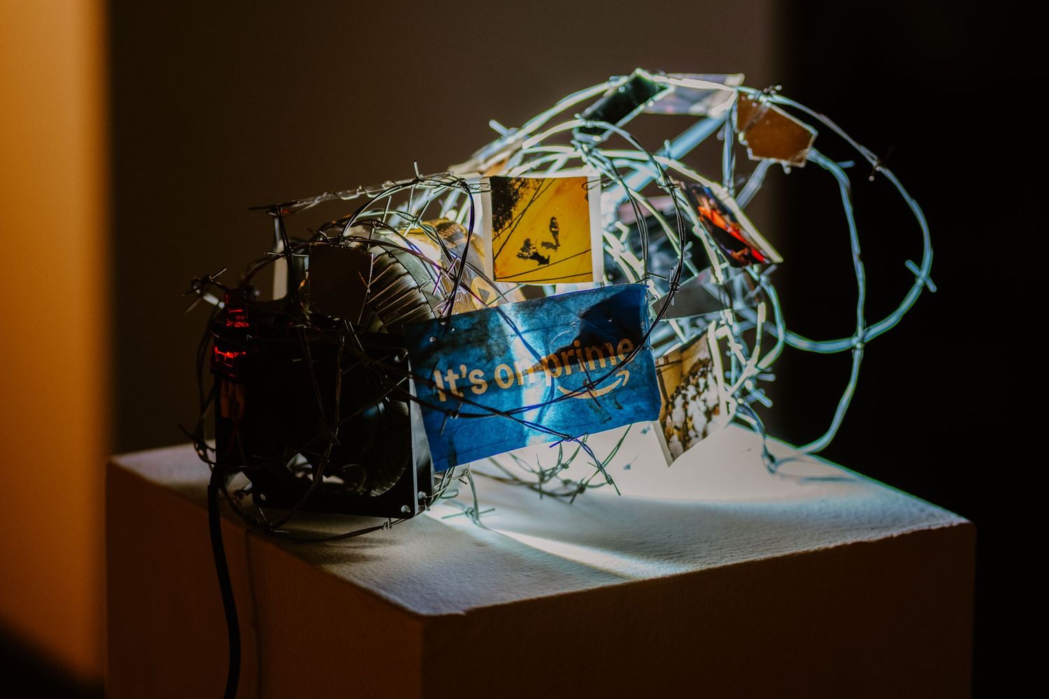 Electronic art installation with blue wiring and components displayed on white surface.