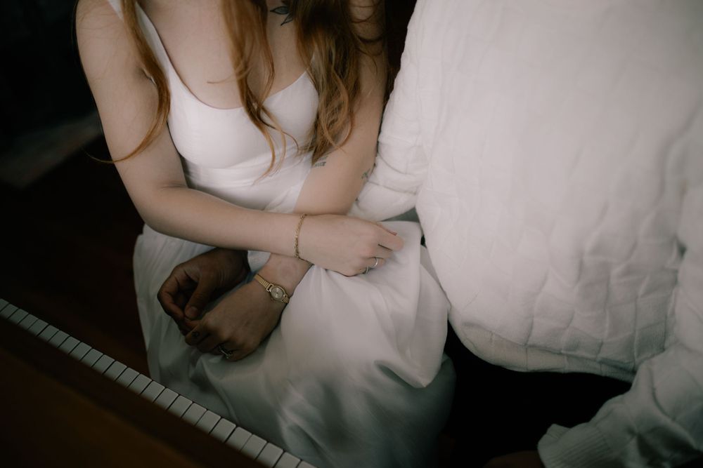 Intimate boudoir photography sequence with soft lighting and white bedding.