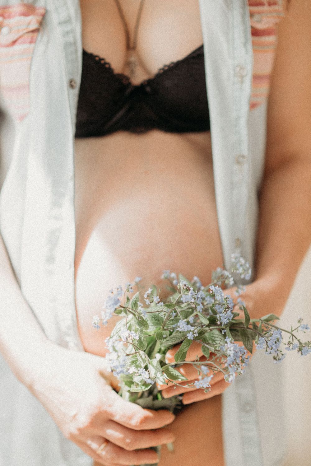 Delicate arrangement of blue forget-me-not flowers held in gentle hands.