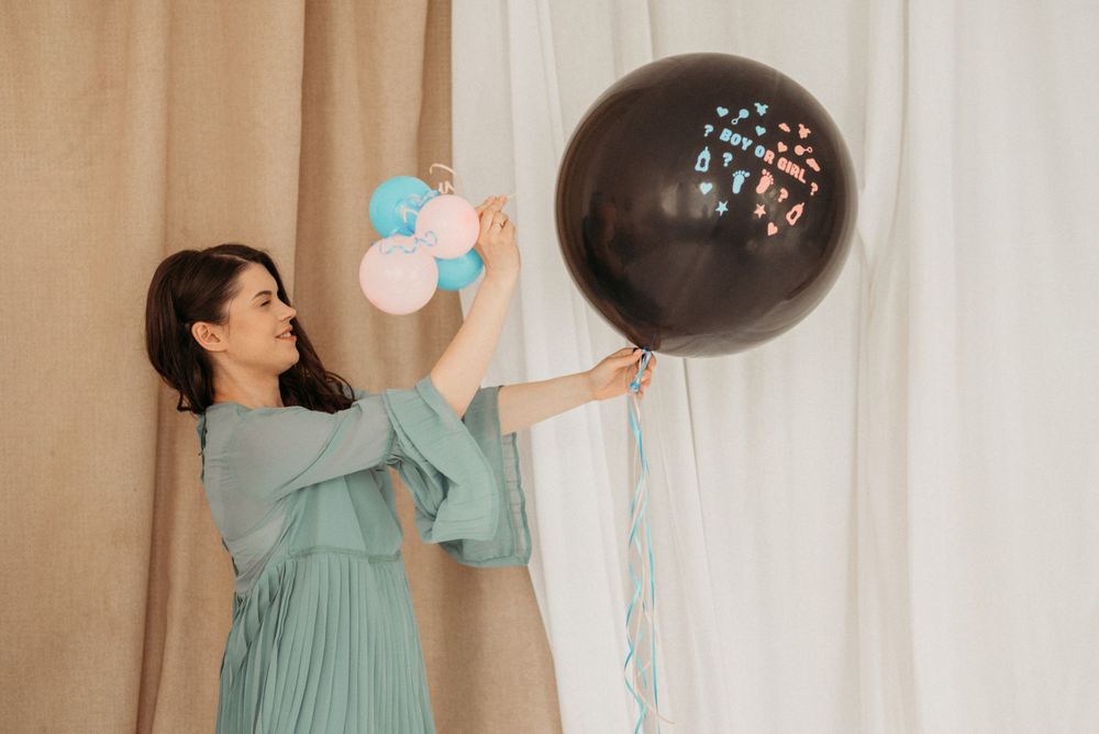 Joyful celebration scene with teal dress and floating pastel balloons against white backdrop.