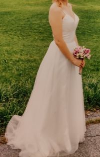Frau in einem weissen Brautkleid mit Brautstrauss