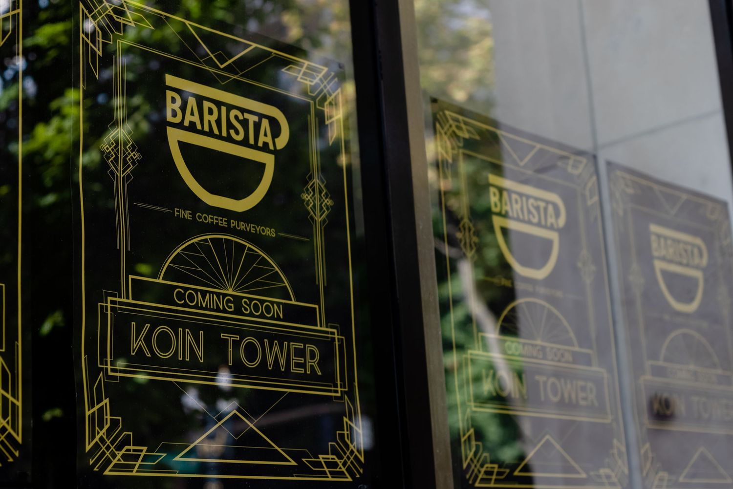Barista coffee shop sign and reflection on glass window at Koin Tower building.