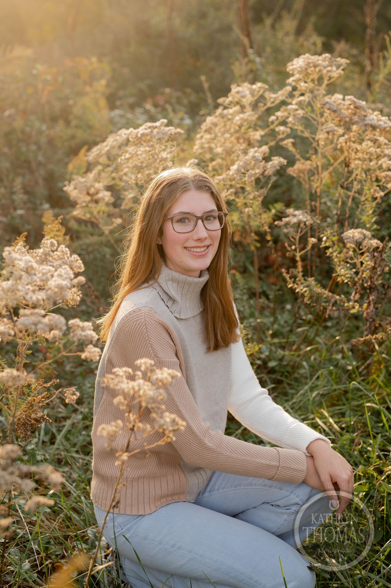 Outdoor autumn portrait with dried flowers featuring someone in a turtleneck sweater and glasses.