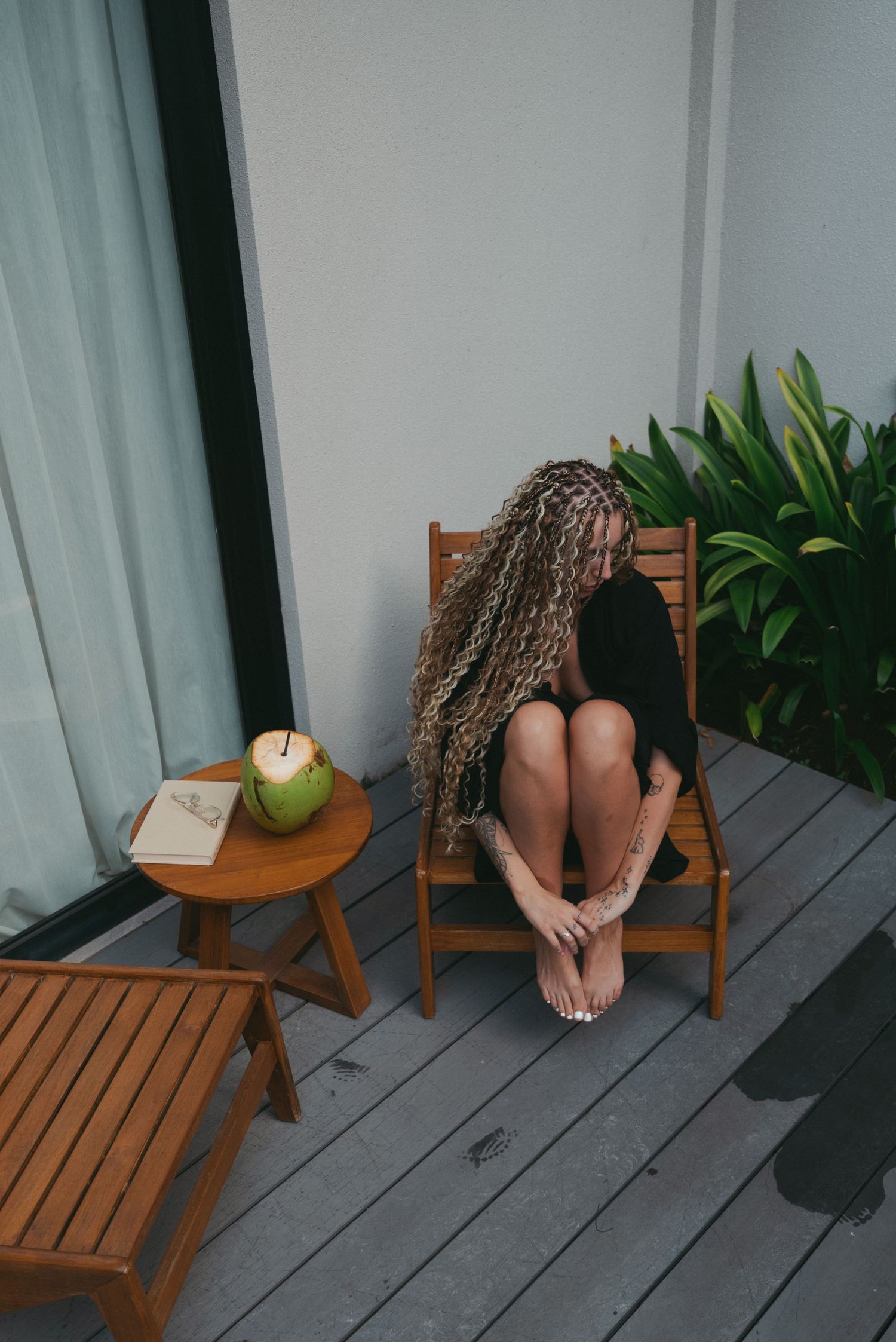 A sequence of photos showing an apple rolling off a wooden outdoor chair onto a gray deck.