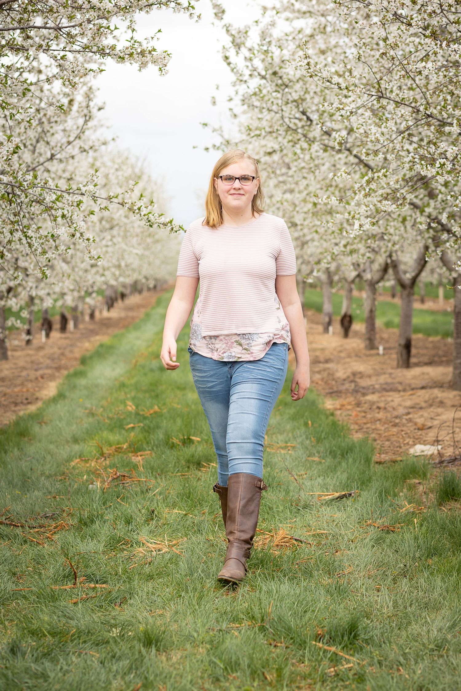girl in pink shirt in apple orchard blossoms utah Rowley's Red Barn