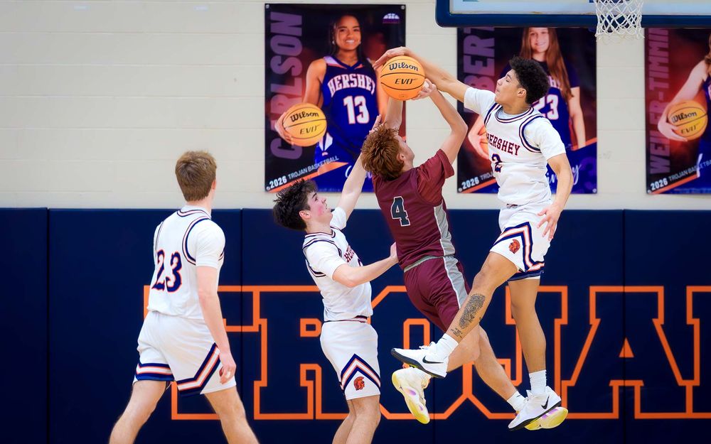 Trojans player block a layup as teammates and opponents look on by SportsFox Photography, Hershey PA.