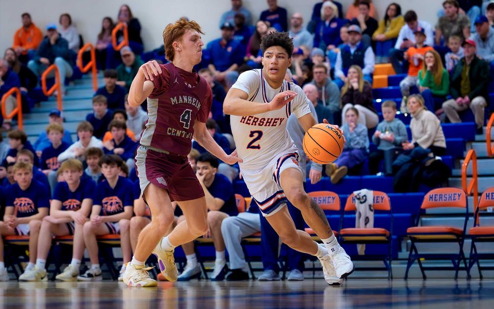 Trojans player drives past a Manheim Central defender with the ball by SportsFox Photography, Hershey PA.