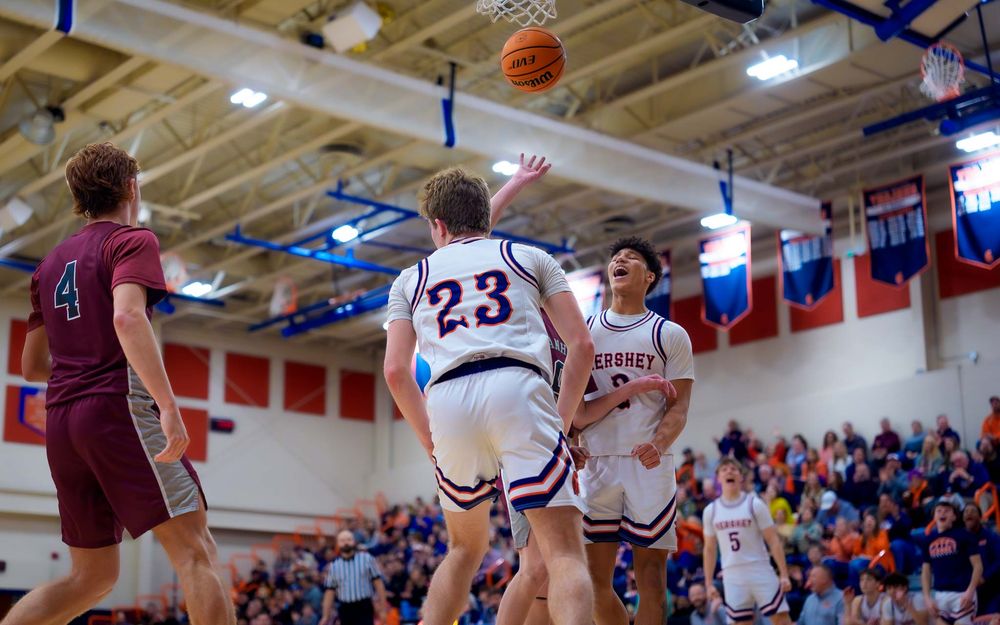 Trojans player celebrates with teammates and defenders nearby by SportsFox Photography, Hershey P