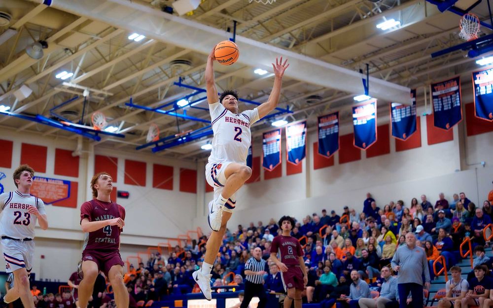 Cam Sweeney leaps for a dunk as the crowd and opponents look on by SportsFox Photography, Hershey PA.