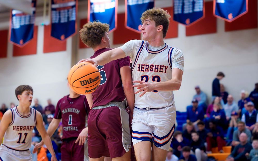 Trojans player passes the ball around a Manheim Central defender by SportsFox Photography, Hershey PA.