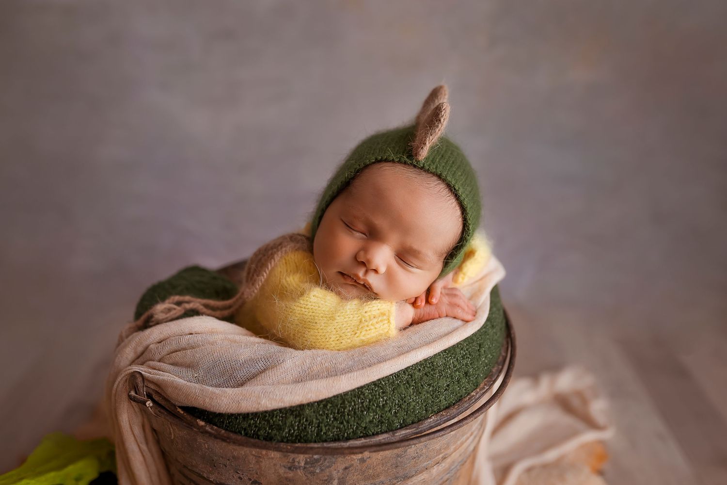 bebe recien nacido fotografiado con gorrito de dinosaurio