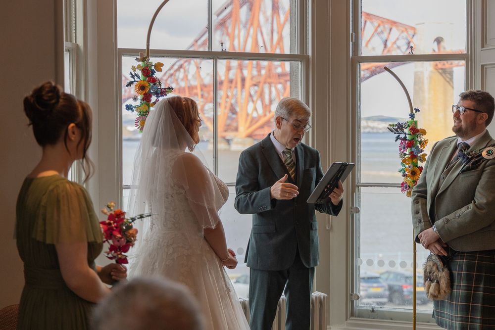 Indoor wedding reception with Forth Bridge visible through large windows.