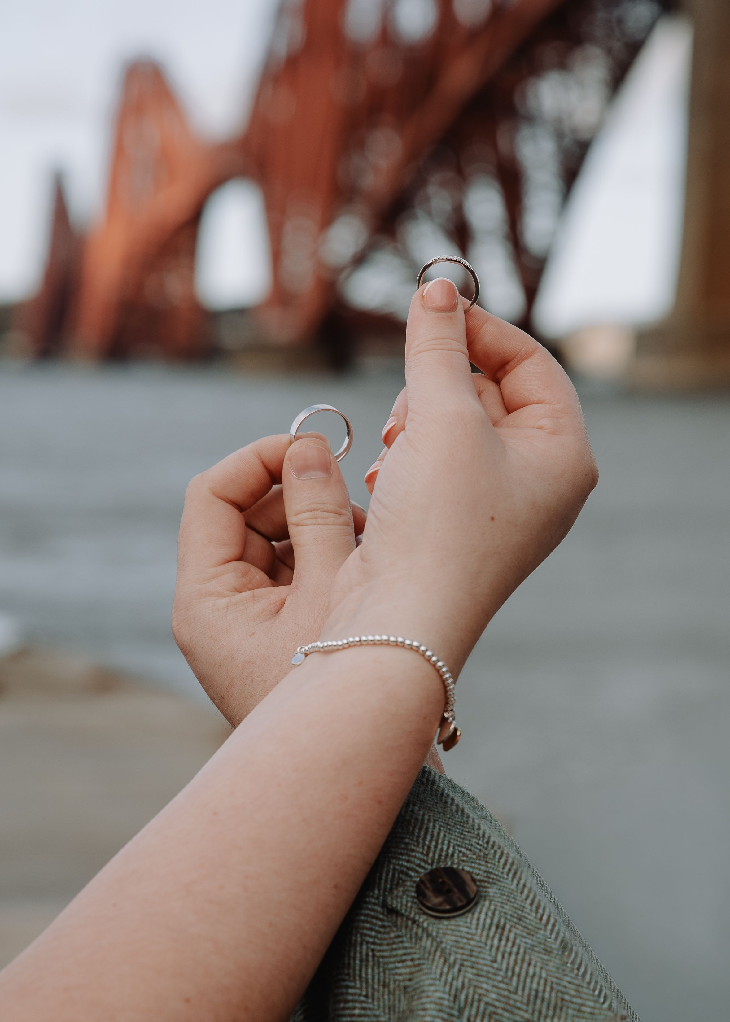 Close-up series showing delicate hand movements with jewelry and rings against a green fabric background.