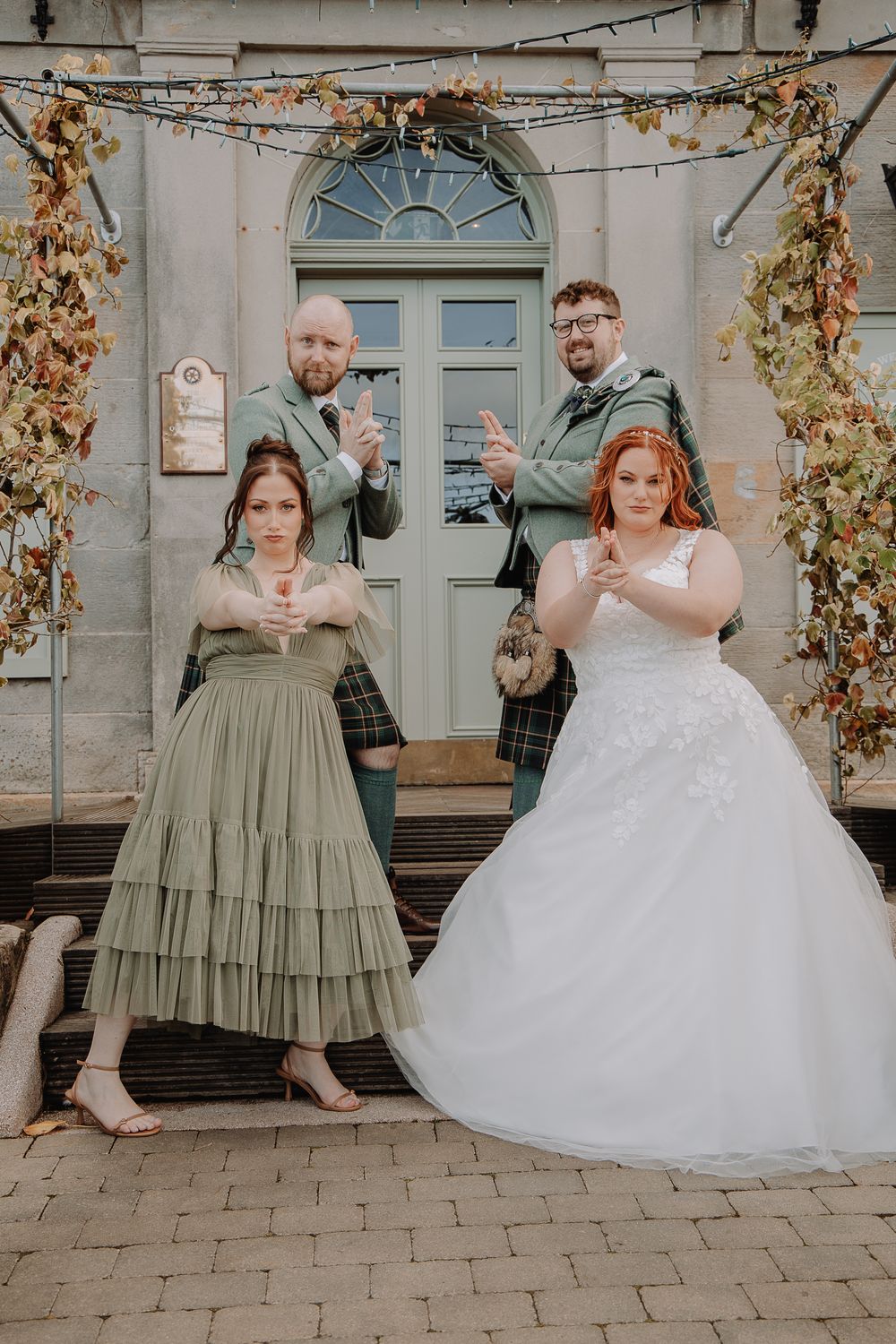 Wedding party performing a fun choreographed dance sequence outside a historic building.