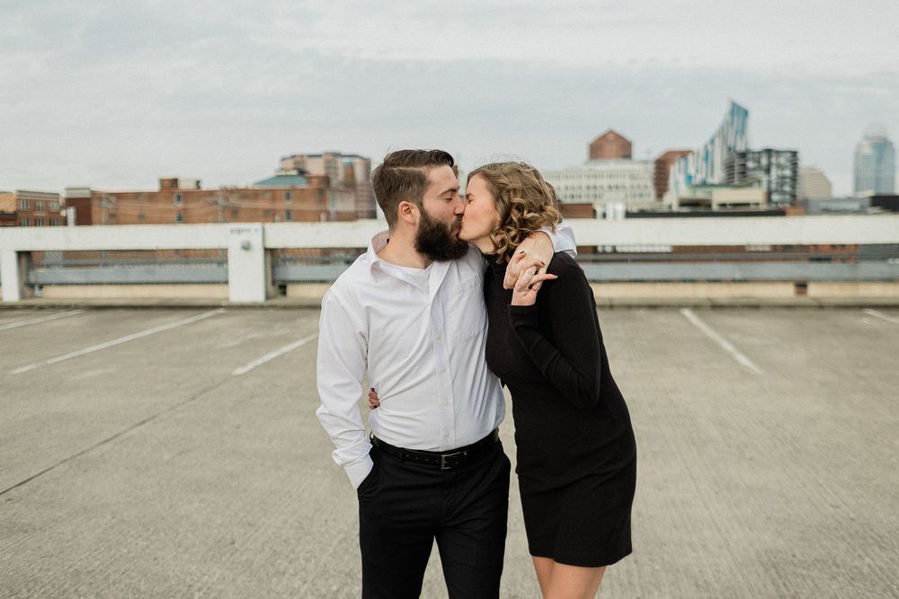 Couple in black and white outfits sharing playful moments against an urban backdrop.
