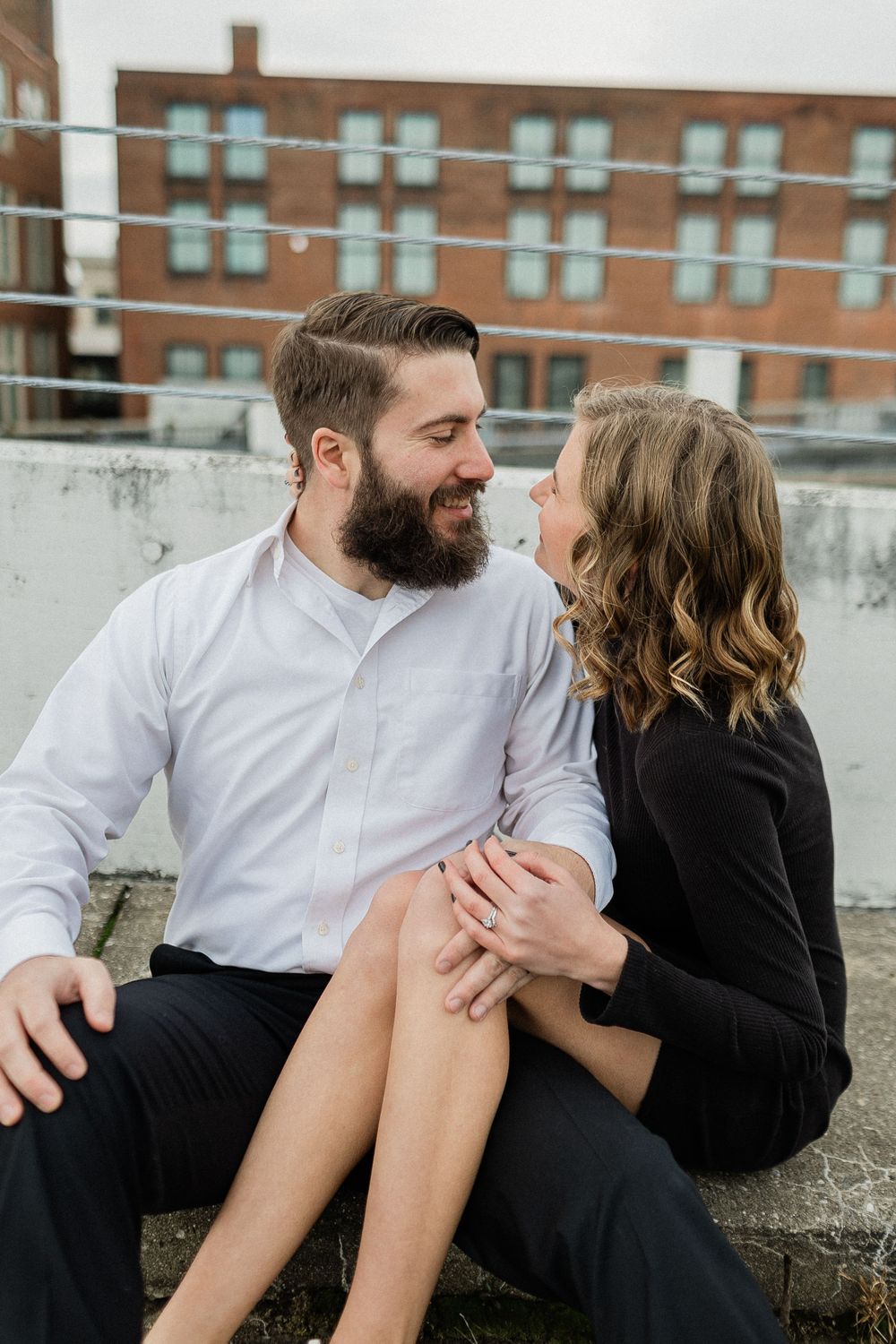 A couple sitting together on concrete steps share intimate moments in three progressive candid shots.