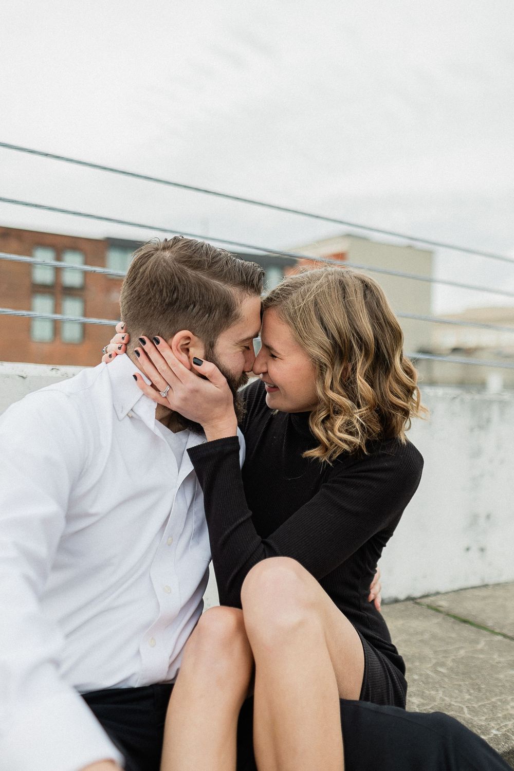 A romantic moment shared between two people on an urban rooftop setting.