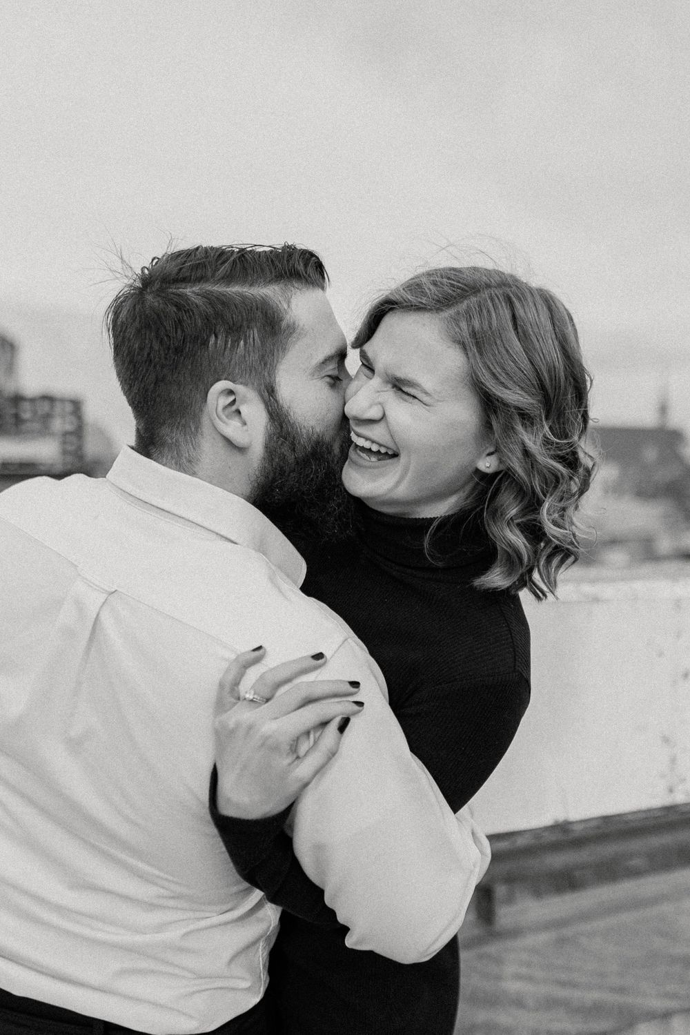 Romantic black and white photo sequence showing a couple embracing and sharing intimate moments on a rooftop.