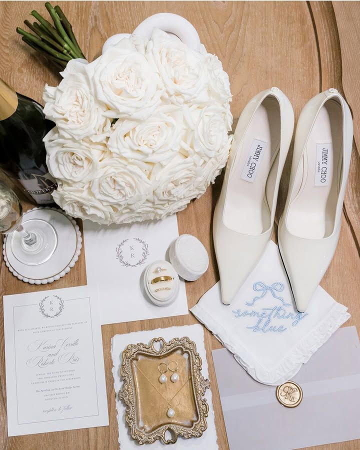 Elegant wedding details in white and blue featuring bridal shoes, floral bouquet, invitations and vintage decor elements.