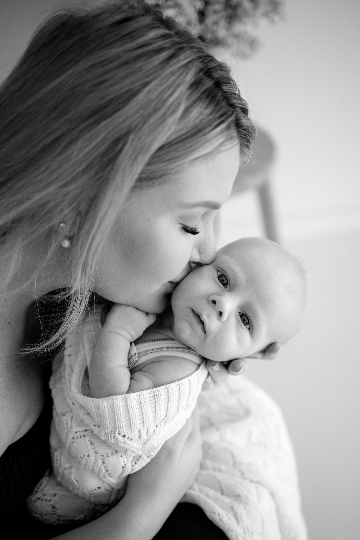 A tender black and white portrait series showing intimate moments between parent and baby.