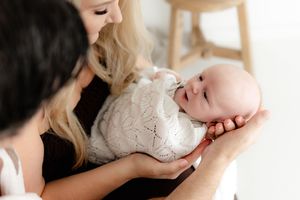 Tender moments captured in a series of black and white photographs showing gentle parent and baby interactions.